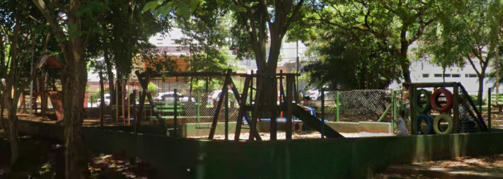 Public kids playground in an area shaded by trees.